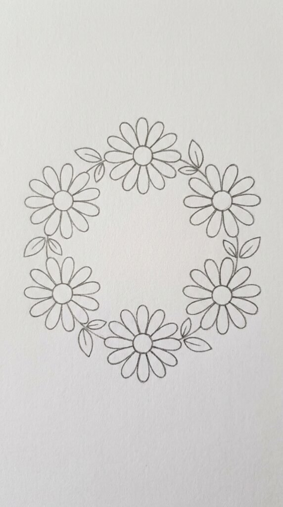 Simple pencil drawing of a daisy flower wreath arranged in a circle with leaves between each daisy, on white paper