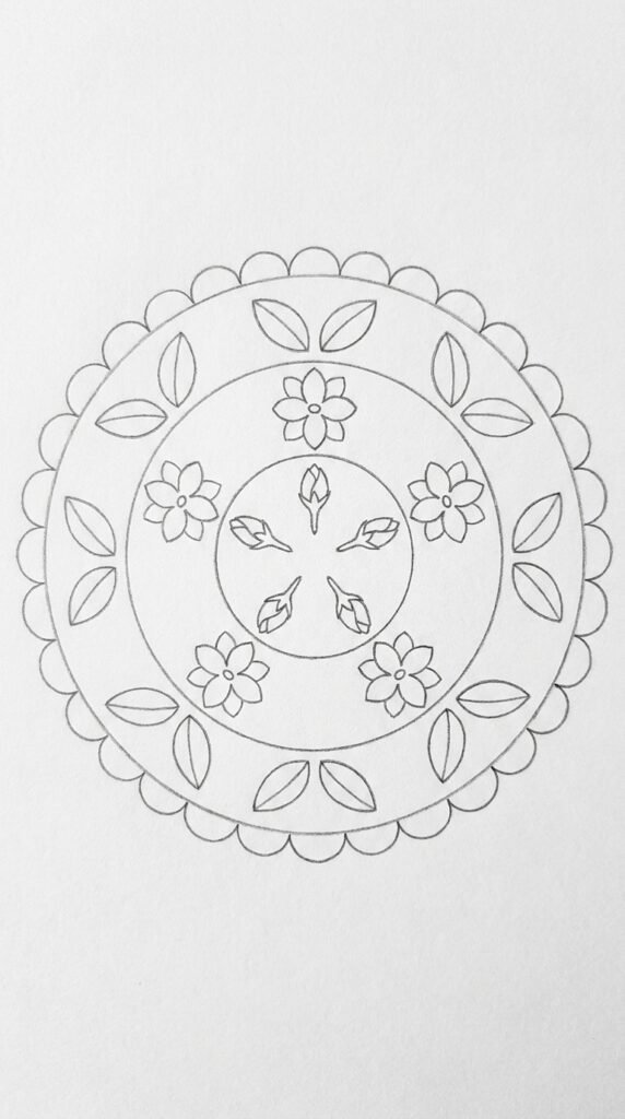 A pencil mandala drawing with concentric rings featuring jasmine buds, open flowers, leaf pairs, and a scalloped outer border in radial symmetry.