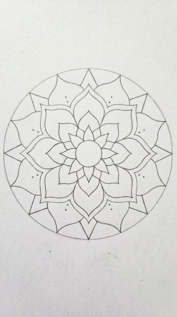 Lotus mandala pencil drawing with three rings of petals and decorative details on white paper.
