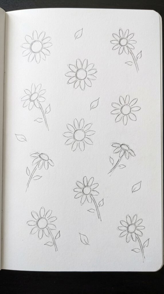 Pencil doodle drawing of multiple tiny sunflowers scattered across the page in a loose pattern style on white paper.
