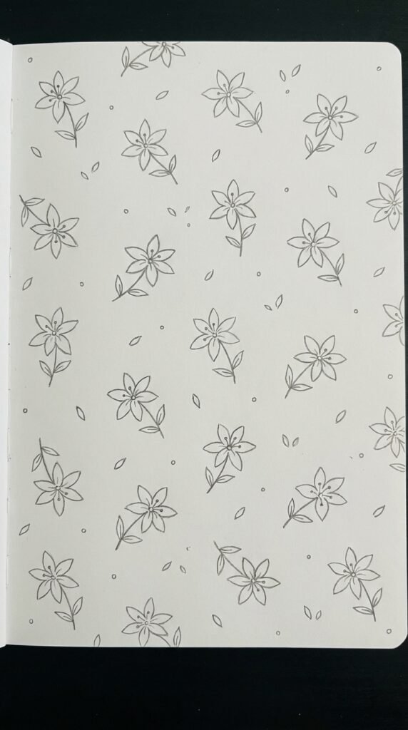 : Mini lily pattern drawing with many small repeated lily outlines scattered across white paper.